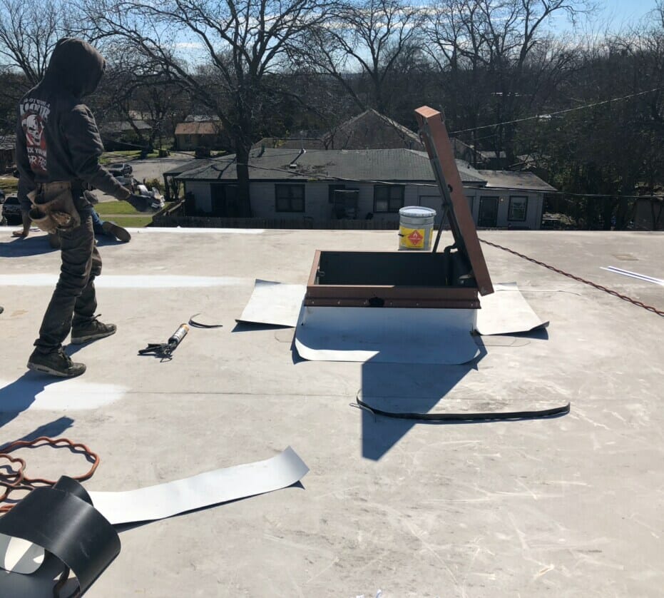 Employees working on a roof with a skylight