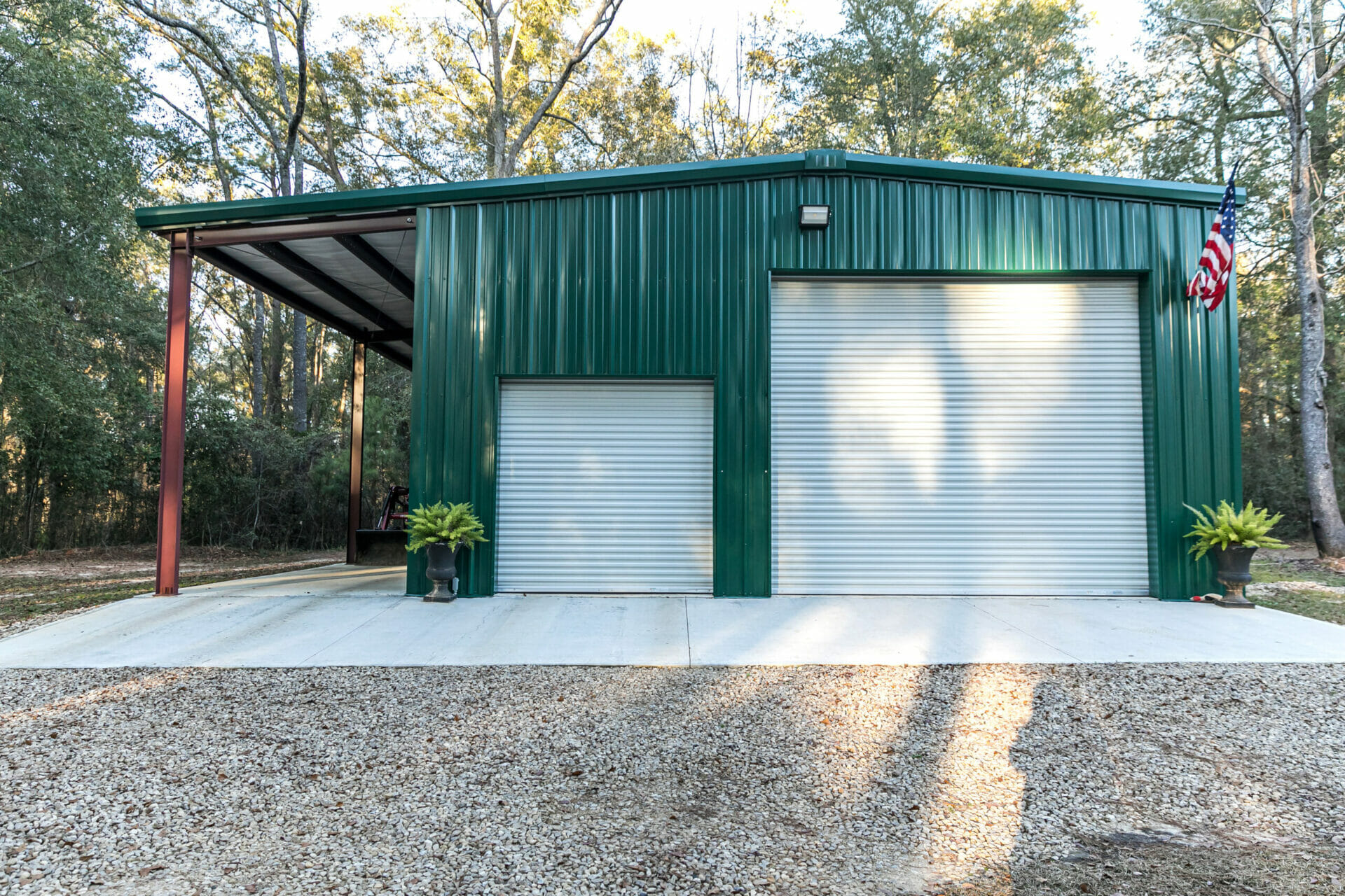 Large green outdoor metal building on a spacious rural property for storage, cars, garage items and a riding lawn mower